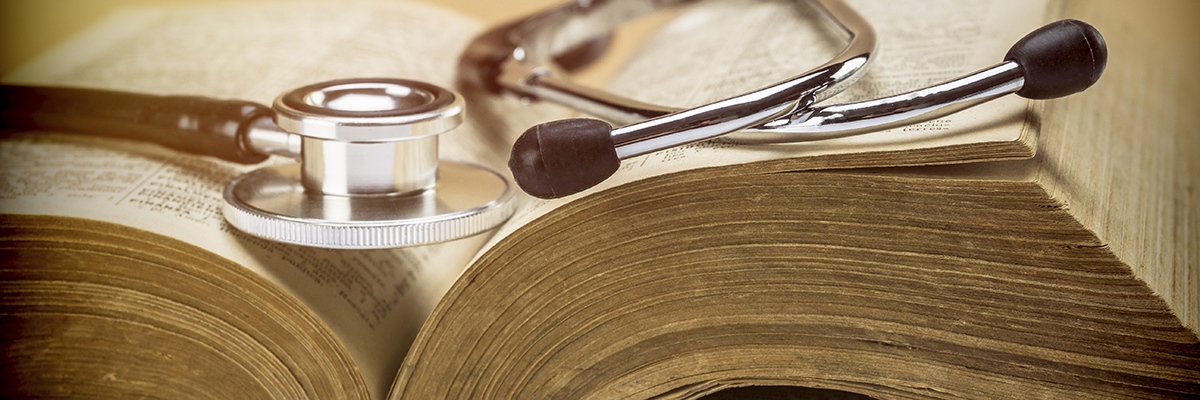 Stethoscope on an old book of medicine, conceptual image